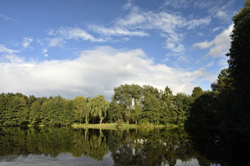 Fototapeta na wymiar Wolkenverhangener See mit Regenbogen, cloudy lake with strong rainbow