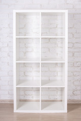 wooden shelf over white brick wall