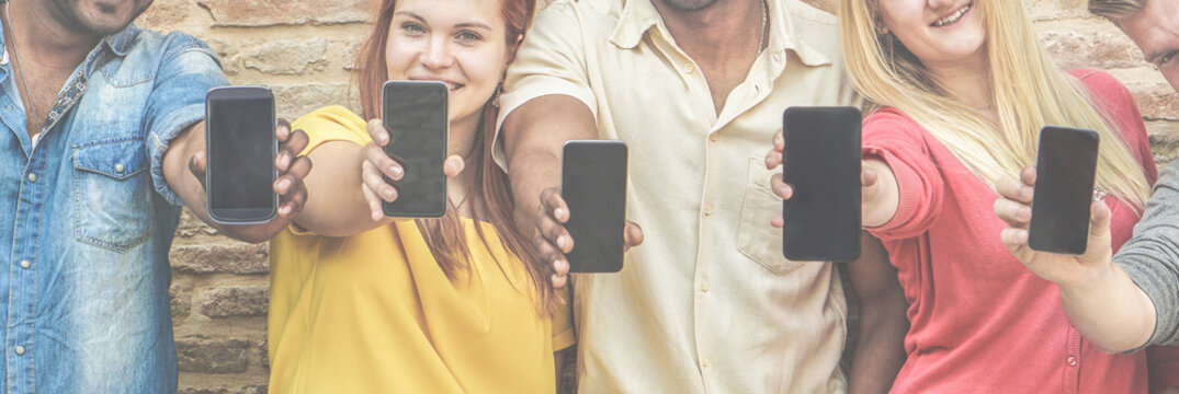 Diverse culture friends with smartphone outdoors - Young multi ethnic students addiction to new technology trends - Happy people having fun with phones - Focus on faces - Contrast retro filter