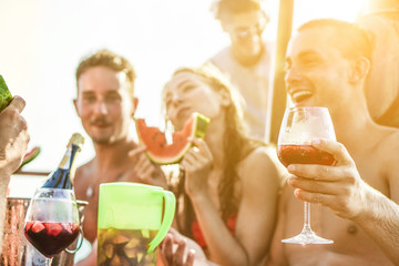 Happy friends drinking sangria wine and eating watermelon at boat party - Young people having fun in summer vacation - Exclusive vacation , friendship , travel concept 