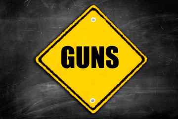guns written on caution sign