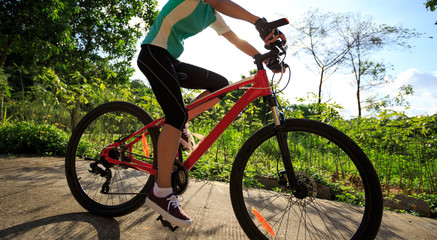 Fototapeta na wymiar woman cyclist cycling on summer forest trail