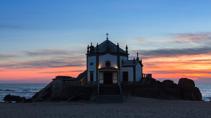 Chapel Senhor da Pedra on Miramar Beach at night, Porto, Portugal.