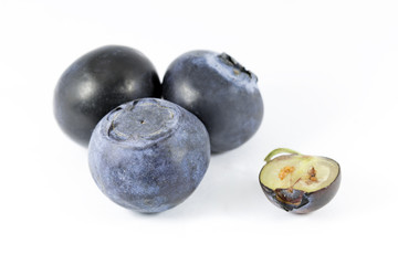 The group of whortleberries isolated on white background. On of them is sliced. Macro photography with natural colors.