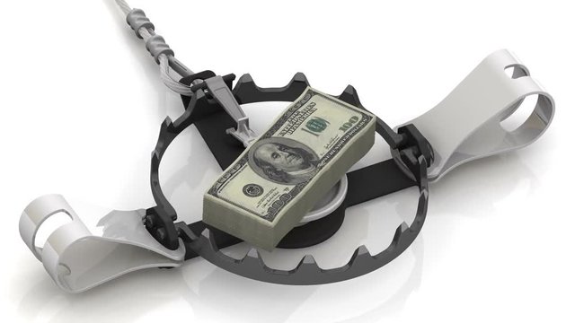 Money as a dangerous lure. Stack of packs of 100 dollar American bills, tied with a ribbon, as bait in trap on a white surface