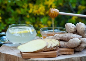 Cup of ginger tea with honey and lemon on a wooden table