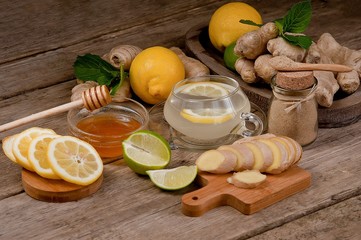 Cup of ginger tea with honey and lemon on a wooden table