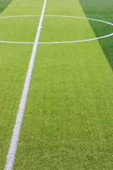 Obraz premium Photo of a green synthetic grass sports field with white line shot from above.