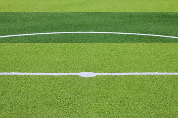 Obraz premium Photo of a green synthetic grass sports field with white line shot from above.