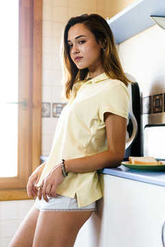 Young confident girl leaning on counter