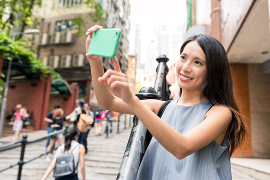 Woman taking photo with cellphone in Pottinger Street