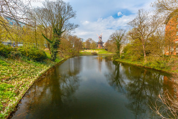 Fototapeta na wymiar Popular city park Wallanlagen with Am Wall Windmill and river in Bremen, Germany