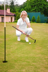 Fototapeta premium Beautiful young woman playing golf on course in summer day