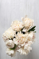Top view of beautiful peonies on wooden table