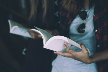 Close up of woman hands holding reading book.