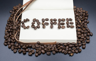 A book with a words of "Coffee" made by the roasted coffee beans with isolated black background.