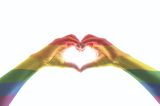LGBT community pride concept with rainbow flag pattern on heart-shaped hands (isolated with clipping path)