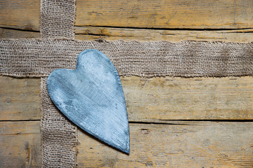 burlap and grey heart on wooden table, copyspace