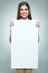 Smiling woman holding white banner wearin striped.