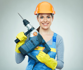 Smiling woman wearing helmet holding drill tool.