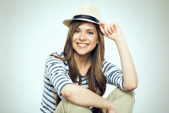 Smiling young woman sitting with folded hands.