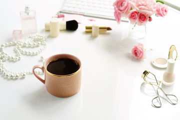 Beauty blog concept. Female make up accessories, cup of cofee and bouquet of pink roses on white background. Flat lay, top view feminine desk, workspace with laptop