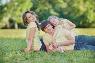 Fototapeta premium Happy family lying on grass in park.
