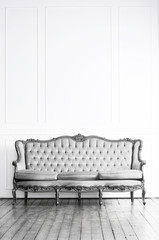 Black and white image of antique sofa in a retro interior. Vintage background.
