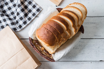 Fresh baked bread and sliced bread on rustic wooden table