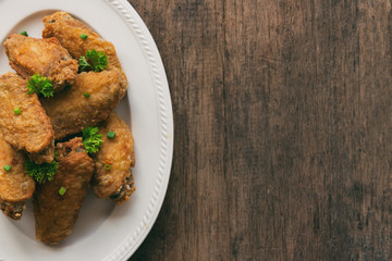 Fried chicken wings served with barbecue dipping sauce. Homemade fried chicken delicious and crispy. Top view with copy space on fried chicken and chili sauce or tomato sauce (ketchup)ready to served