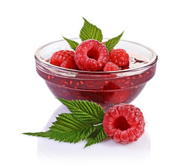 Close up view jam in glass bowl with fresh ripe raspberry and leaves