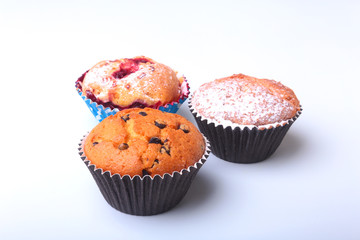 Homemade Blueberry and chocolate muffins with powdered sugar and fresh berries.