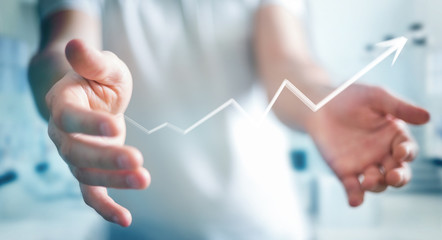 Businessman holding hand-drawn arrow going up