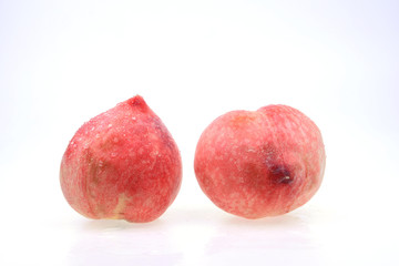 Fresh peaches stand in a white background
