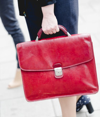 Young adult business woman holds red leather briefcase