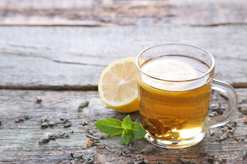 Cup of tea with lemon and mint on wooden table