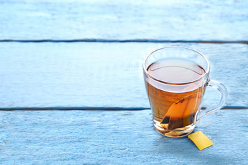 Cup of tea with teabag on blue wooden table