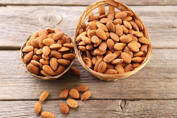 Almonds in basket on grey wooden table