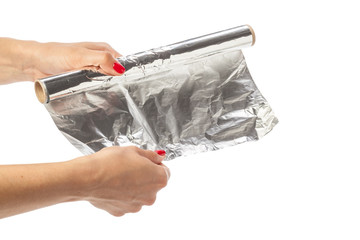 human hand holding a roll of foil on a white background