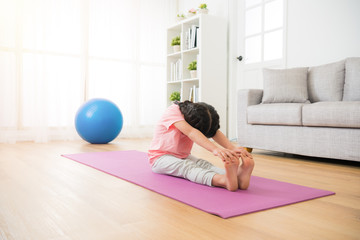 girl sitting on the wooden floor with mat