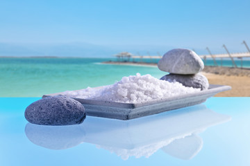 Fototapeta na wymiar Sea salt on a glass table with stones and cockleshells