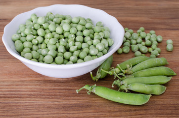 Guisantes en plato sobre fondo de madera