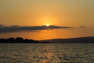 A view of a golden sunset over the sea. The light of the sun reflected in the water as the beam path.