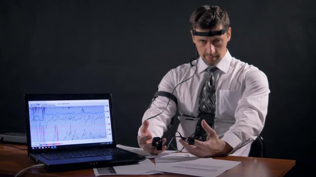 Mid shot of the man connected to the lie detector. 4K.