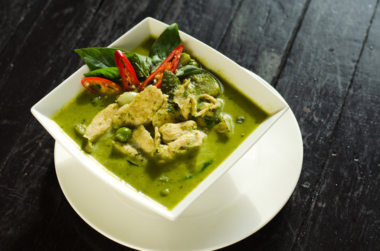 Thai Food: Green curry in white bowl on wood table