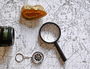 old military topographical map, pencil, vintage photo camera, mineral stone, magnifier and compass