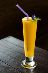 Fresh tropical fruit smoothie mango juice on wooden background