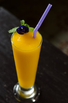 Fresh tropical fruit smoothie mango juice on wooden background