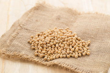 Close up soy beans on wooden table background.