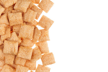Golden pads corn flakes isolated with copy space background. Cereals texture.